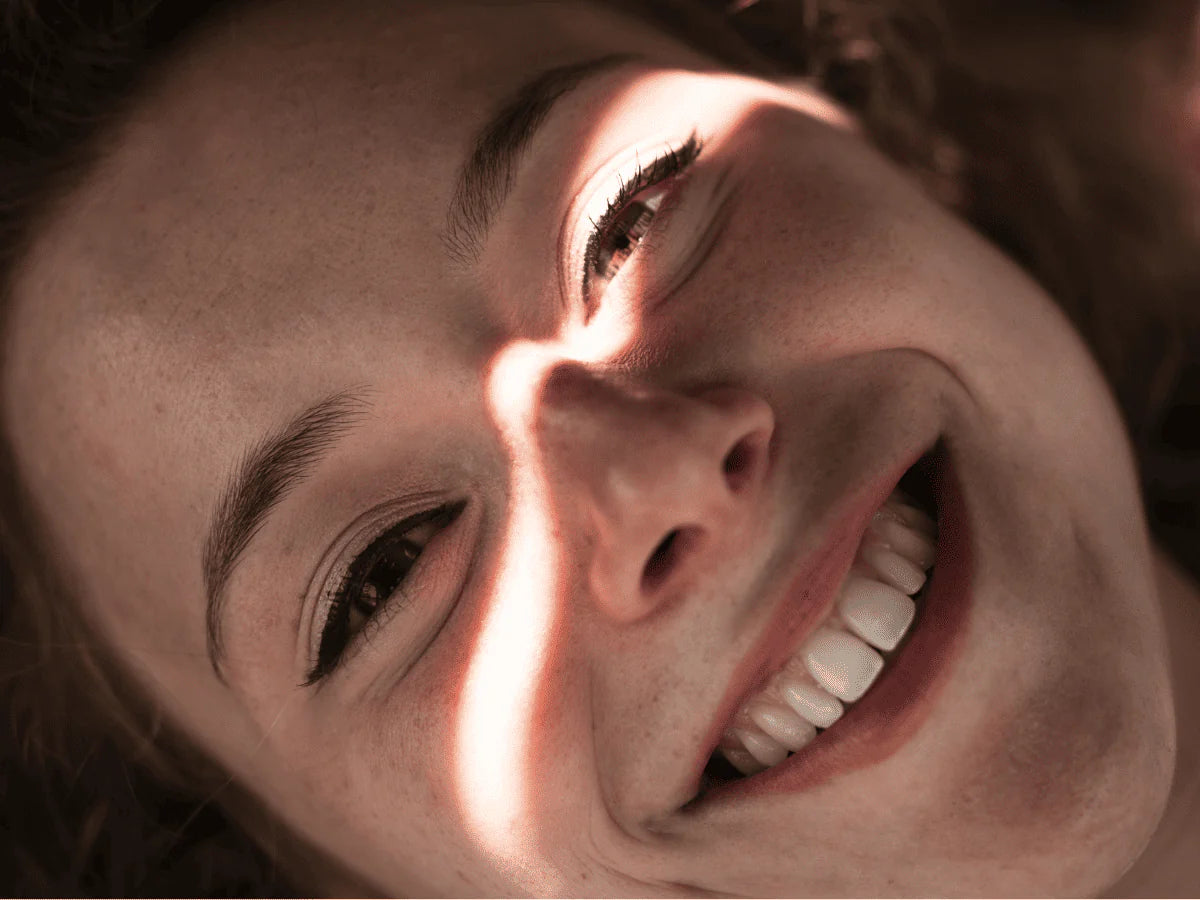 Femme souriante illustrant la santé du microbiote oral et bucco-dentaire